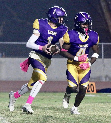 Tiger quarterback Johnny Cunha follows Travan Gaffney as he picks up yardage in Friday night's game against Tulare Wesrn.